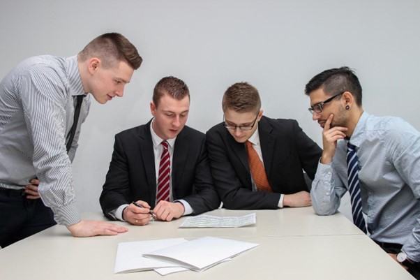 Four men looking at some papers on the table