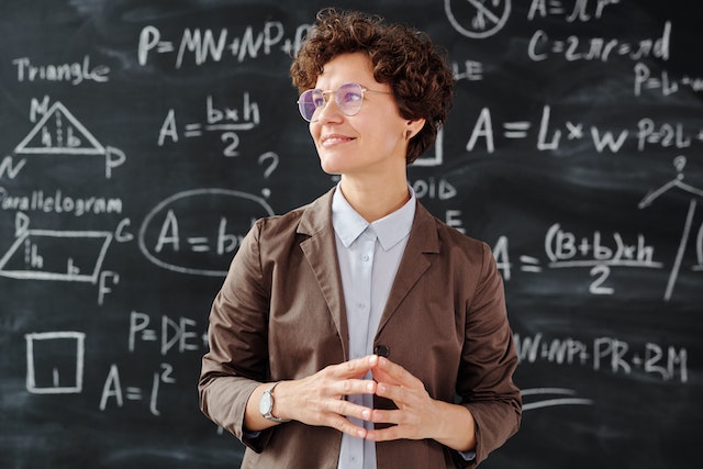 Professor in brown blazer wearing glasses